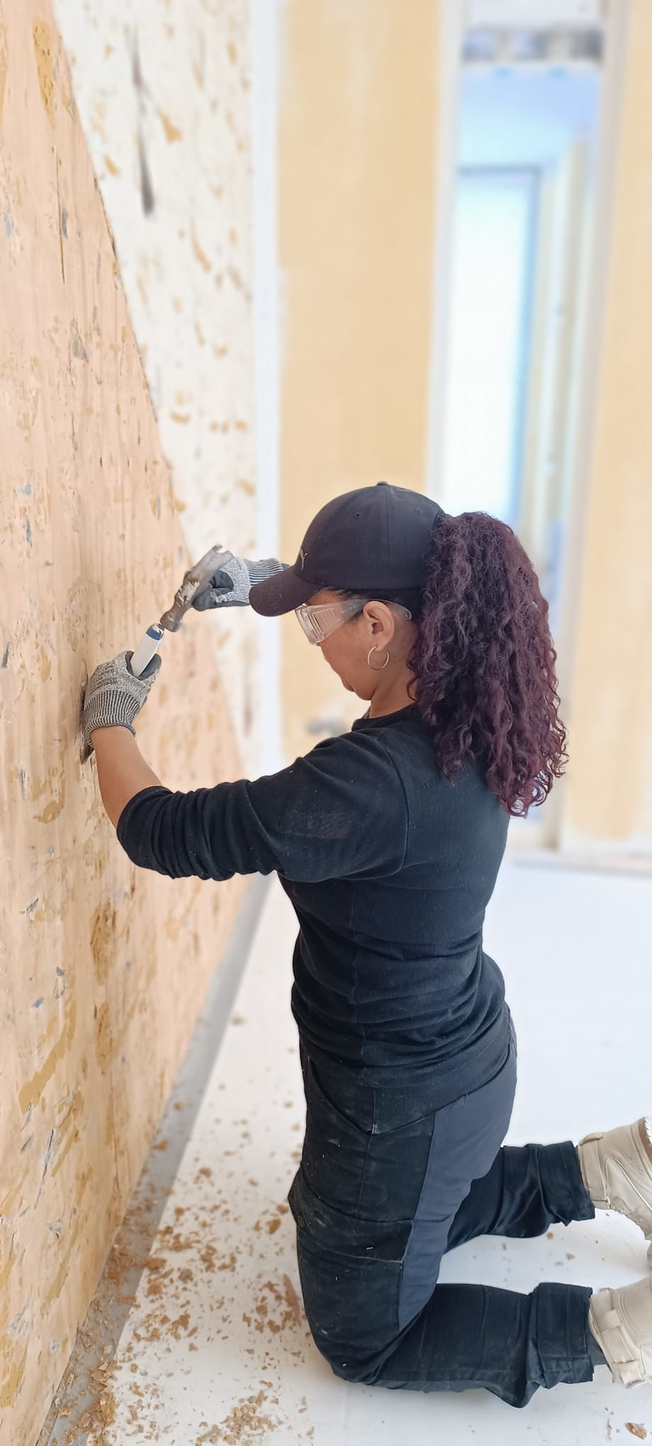 J.C. Multiservices team member preparing an existing wall surface by hand